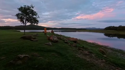 The atmosphere by the river in the evening, with views of mountains and forests. Video stock 337286659