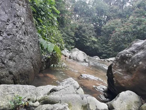 The atmosphere in a river whose flow is quite calm and surrounded by rocks. Stock Photos