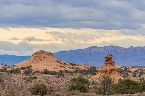 Atmospheric clouds hover over red rock formations Stock Photos