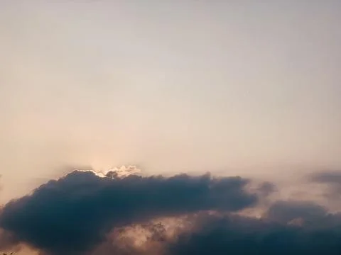 Atmospheric Cloudscape with Warm Light Behind Dark Clouds Stock Photos
