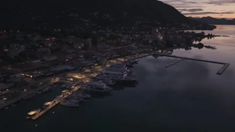 Atmospheric drone footage captured during blue hour above a coastal harbor town Stock Footage 336453070