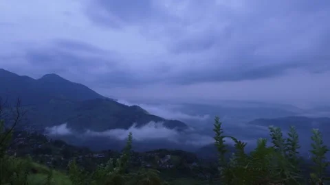 Atmospheric low-lying mist and clouds rolling over lush green rolling hills of Stockbeeldmateriaal 346251314