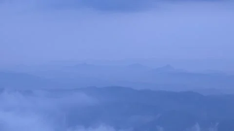 Atmospheric low-lying mist and clouds rolling over lush green rolling hills of Stockbeeldmateriaal 346251321