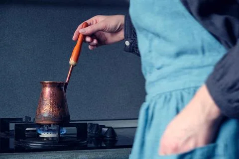 Atmospheric process of making coffee in an old copper cezve, a blurry femal.. Stock Photos