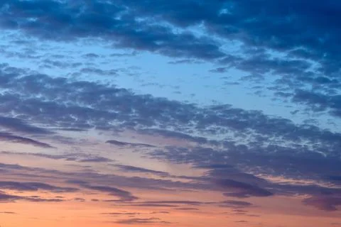 Atmospheric sunset cloudscape featuring deep blue storm clouds Stock Photos