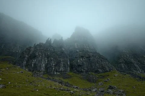 Atmospheric view of high sharp cliffs covered in fog Stock Photos