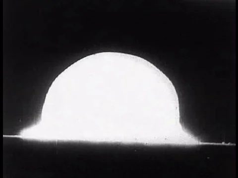 An atomic bomb explodes and a man goes home to his family after a hard day at Stock Footage 75306633