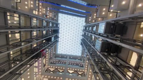 Atrium interior looking up at glass elevators Stock Photos