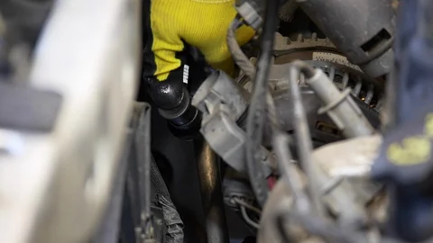 Attaching coolant nozzle to air-conditioning part of a car's motor. Stock Footage 100524001