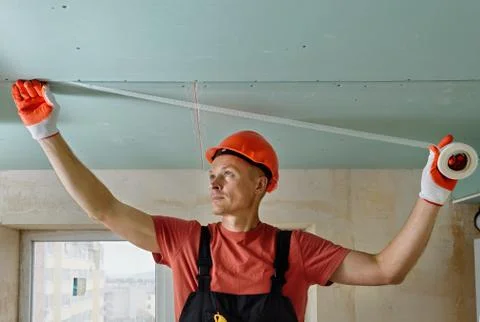 Attaching  mesh to the plasterboards. Stock Photos