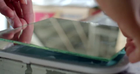 Attaching a new mirror panel over a cracked or broken glass mirror. Stock Footage 312311951