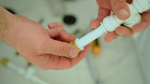 Attaching plastic pipe to brass threaded adapter, bridging materials in plumbing Stock Footage 335144056