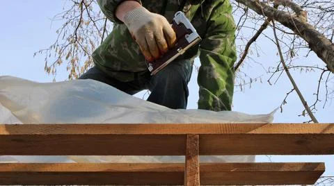 Attaching plastic protective material with a stapler Stock Photos