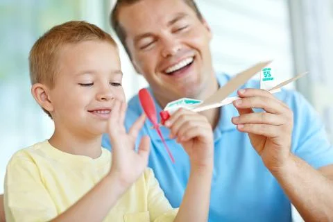 Attaching the propeller. Young boy playing with his toy airplane beside his Stock Photos