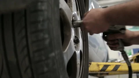 Attaching wheel to a car with pneumatic screwdriver Stock Footage 62410678
