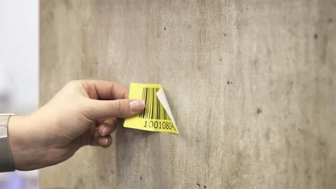 Attaching a Yellow Logistics Barcode Sticker to a Concrete Wall and Scanning It 動画素材 118547876