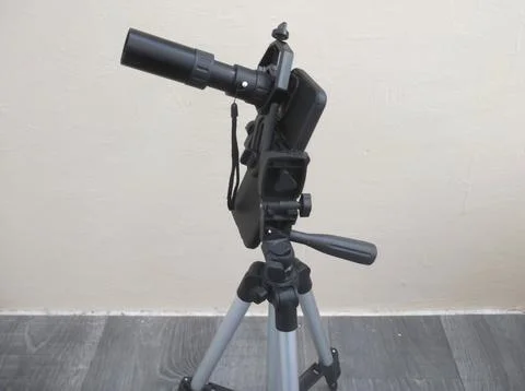 Attachment between monocular telescope and smartphone on a tripod Stock Photos