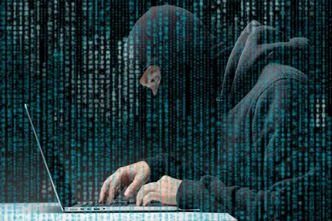 Attacker picks code to computer Attacker in black bakalaver picks code to ... Stockfoto's