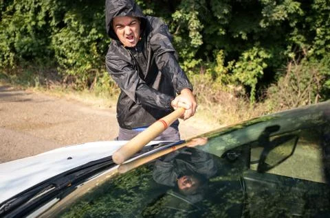 Attacker trying to break a windshield with a baseball bat Stock Photos