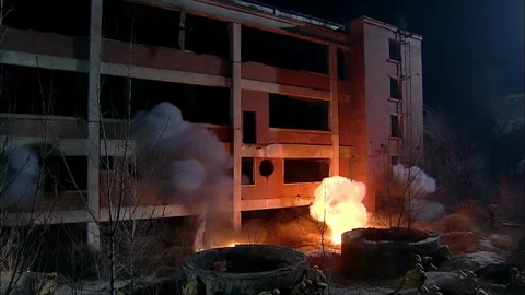 Attacking tall buildings with artillery shells at night Stock Footage 316814690