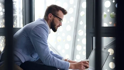 Attantive high-skilled 30-aged bearded businessman drinking coffee during his Stock Footage 118078558