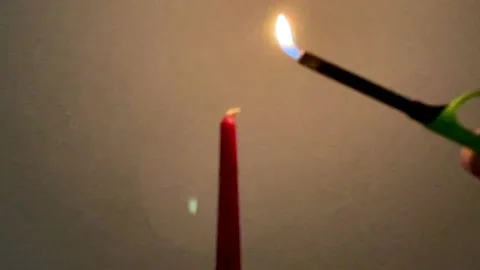 Attempt to light the red candle with a lighter Stock-Footage 221482657
