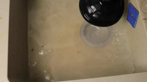 Attempting to clear clogged kitchen drain by plunging with black rubber plu.. Video stock 318902255