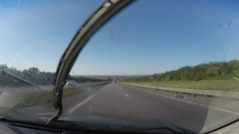 Attemt to clean windschield with wipers. POV car driving on road Stock-Footage 106553776