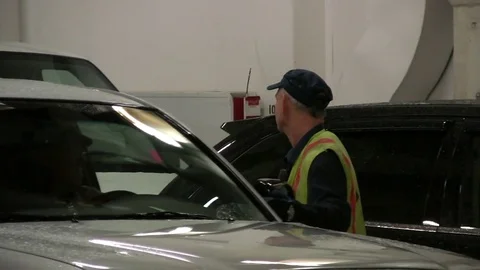 Attendant directs a driver into parking space on Alaskan ferry. Stock Footage 79408790