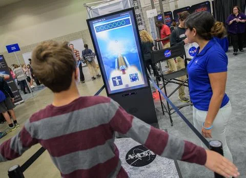 An attendee guides NASA's Space Launch System in an interactive exhibit dur.. Stock Photos