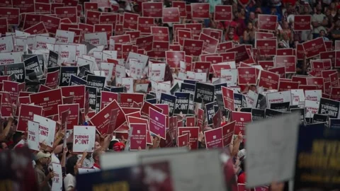 Attendees hold Never Surrender signs at the Charlie Kirk memorial service Stock Footage 345298109