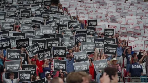 Attendees hold Turning Point signs at the Charlie Kirk memorial service Stock Footage 345298047