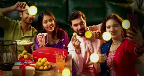 Attending Diwali video call with sweets in decorated home in festival Stock-Footage 342382859