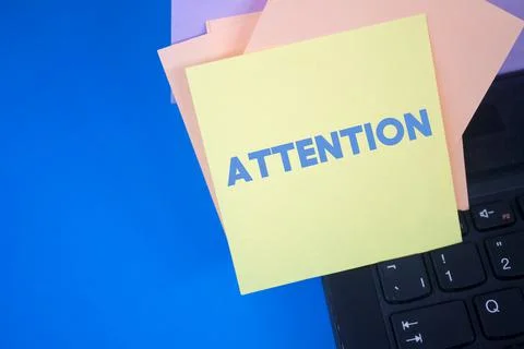 Attention. Text on adhesive note paper. Event, celebration reminder message. Stockfoto's