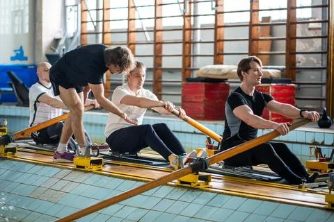 Attentive experienced coach instructs rower crew, correcting posture ensuring Stock-Fotos