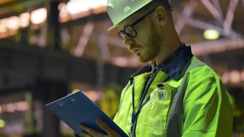 Attentive factory worker maintaining record on clipboard Stock Footage 106571192