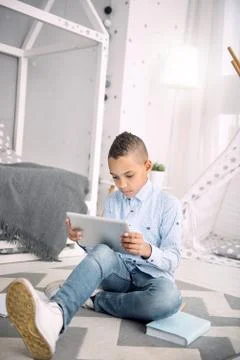 Attentive intelligent boy picking up learning program Foto stock