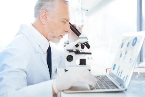 Attentive lab assistant looking into ocular Foto stock