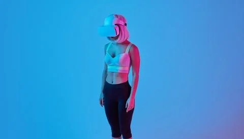Attentive lady exploring virtual reality in modern headset in studio Stock Photos