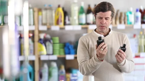 Attentive man chooses perfume or aromatic incense in a supermarket Stock-Footage 311840189