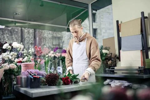 Attentive man trying to compose unusual bouquet Stock Photos