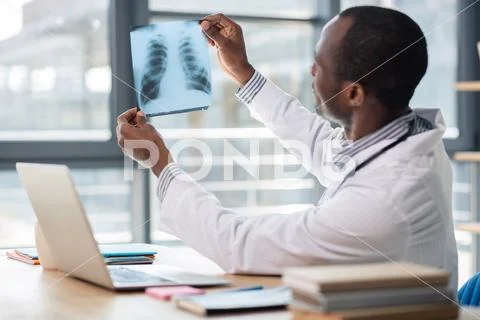 Attentive medical worker looking at roentgen Stock Photos