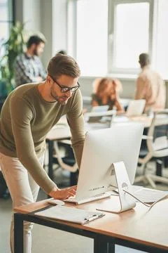 Attentive office worker using computer at workplace Stock Photos