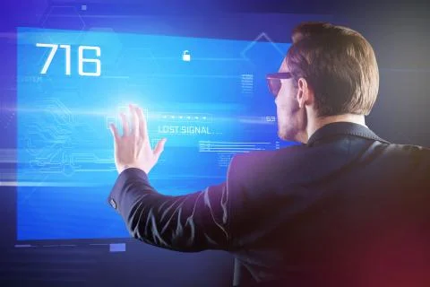 Attentive programmer carefully touching the screen of his futuristic computer Stock Photos