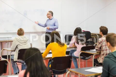 Attentive students with teacher in the classroom Stock Photos