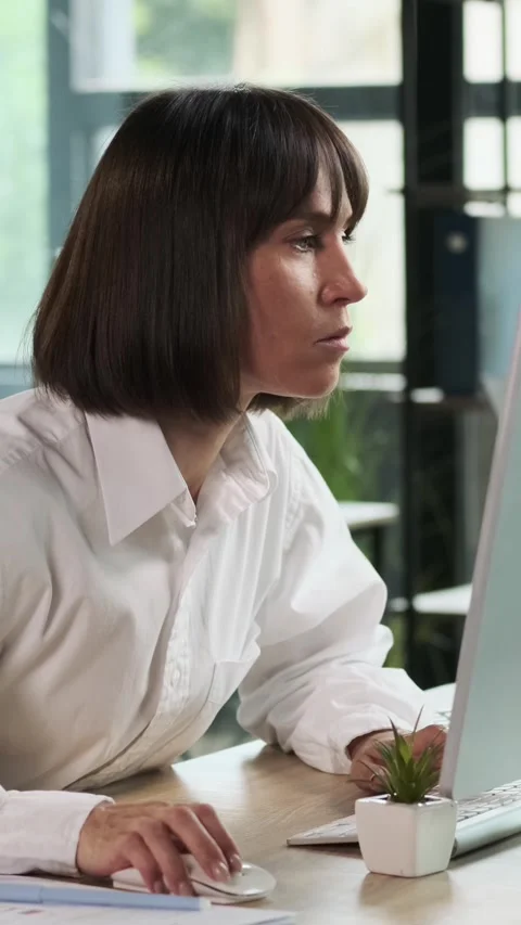 Attentive Woman Thinking And Using Desktop Computer In The Office Stock Footage 281552891