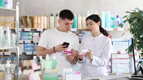 Attentive young guy choosing box of paracetamol antipyretic pills, scan QR code Video stock 318942517