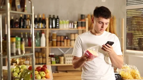 Attentive young guy is scanning QR code on cheese in grocery store Stock Footage 326319608