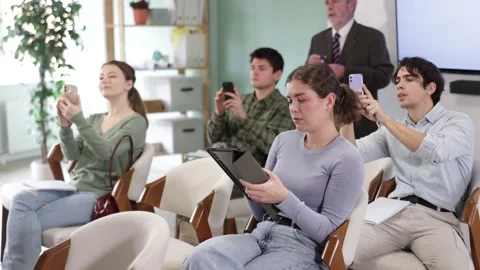 Attentive young students using smartphones and tablets to take photos during a Stock Footage 343164815