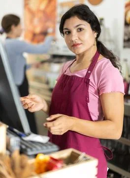 Attentive young waitress checking orders on monitor in cafeteria Stock-Fotos